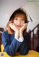 A woman sitting at a table with a book on her head.