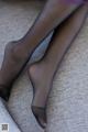 A close up of a woman's legs in black stockings.