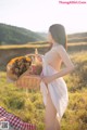 A woman in a white dress holding a basket of flowers.