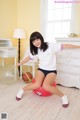 A woman sitting on an exercise ball in a room.