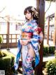 A woman in a blue and white kimono posing for a picture.