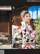 A woman in a kimono standing in front of a building.