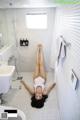 A woman laying on the floor in a bathroom.