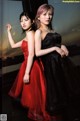 Two young women in black and red dresses posing for a picture.