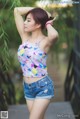 A woman in shorts and a tank top posing for a picture.