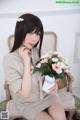 A woman sitting on a chair holding a bouquet of flowers.