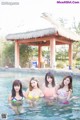 A group of women in bikinis standing in a pool.