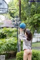 A woman holding a basketball in front of a basketball hoop.