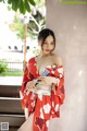 A woman in a red kimono posing for a picture.