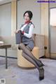 A woman sitting on a chair holding a briefcase.