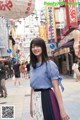 A woman standing in the middle of a busy street.